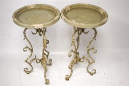 A pair of small round tables with metalwork supports.