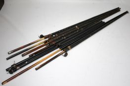 A collection of snooker cues, including some vintage examples.