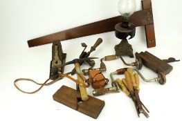 A collection of assorted vintage hand tools. Including drills, planes, chisels, an oil lamp, etc.