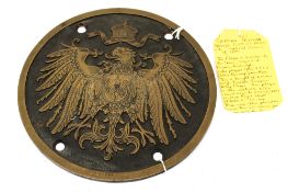 A Prussian bronze circular wall plaque. Showing a single Imperial eagle, with four bolt holes.