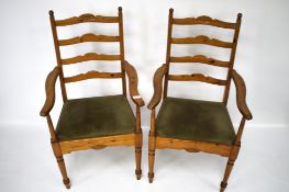 A pair of pine ladder back open armchairs.