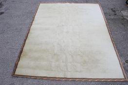 A cream carpet with acanthus leaf boarder.