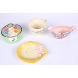 A collection of four assorted pieces of Clarice Cliff pottery.