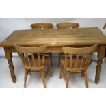 A contemporary pine kitchen table and a set of four chairs.