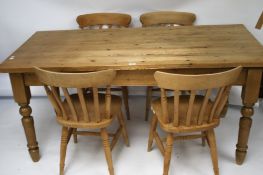A contemporary pine kitchen table and a set of four chairs.