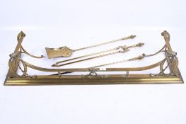 A Victorian brass fire fender and three fire side tools.