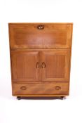 Vintage / Retro : A Blonde Ercol cabinet comprising of a fall front top over a two cupboard door