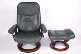 A green leather Stressless recliner arm chair and matching footstool. On a circular wooden base.