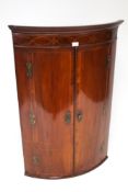 A Victorian inlaid mahogany bow fronted corner cabinet. With four interior shelves and two drawers.