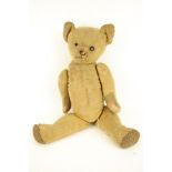 A vintage jointed teddy bear.