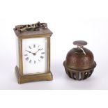 A French carriage clock and a brass bell.