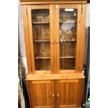 A contemporary pine part glazed display cupboard.
