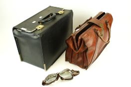 Two assorted briefcases and a pair of motorcycle goggles.