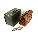 Two assorted briefcases and a pair of motorcycle goggles.