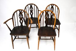 A set of four Ercol dining chairs. Arch top spindle back, two carvers and two others.