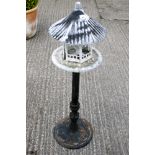 A contemporary pagoda style birds table with metal stand.