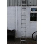 A two piece extending aluminium ladder. With eleven rugs each.