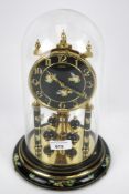 A German torsion clock by Kundo West Germany under glass dome.