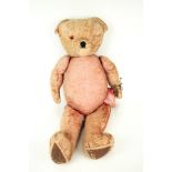 A large English vintage jointed teddy bear with a growler.