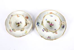 Two late 19th century Meissen flower encrusted teacups and saucers.