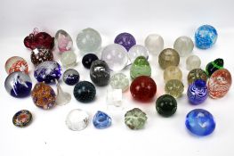 A large collection of assorted glass paperweights.