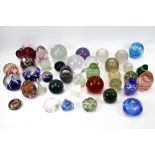 A large collection of assorted glass paperweights.