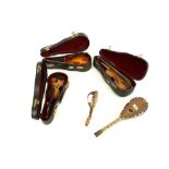 Three vintage miniature violins and two tortoiseshell mandolins.