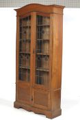 An Edwardian ( slight Arts and Crafts) bookcase with stained and leaded glass doors before an
