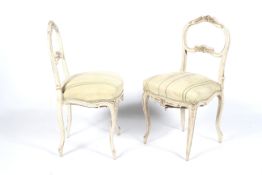 A set of four circa 1900 French painted chairs with sprung seats and floral stripped upholstery,