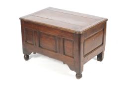An early 18th century smaller oak coffer with rounded corners, three panel front, ball feet ,
