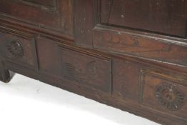 An 18th century French Oak cupboard with a pair of doors before shelves having three panels to