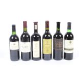 Six bottles of assorted red wine. Compri