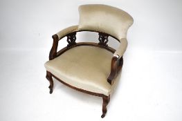 An Edwardian elbow chair. The carved mah