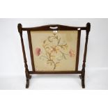 A mahogany framed fire screen with needl