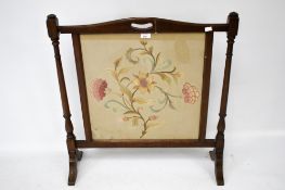 A mahogany framed fire screen with needl