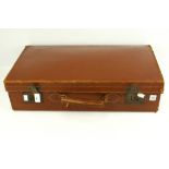 A vintage brown leather suitcase. With c