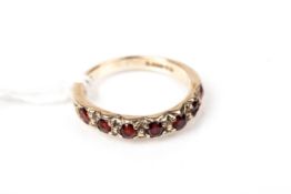 A vintage 9ct gold and round mixed-cut garnet seven stone ring.