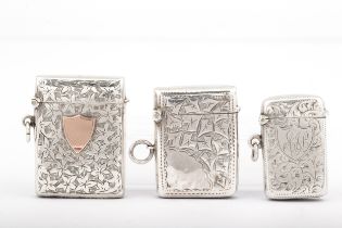Three Edwardian silver vesta or match cases all engraved with foliate scrolls.