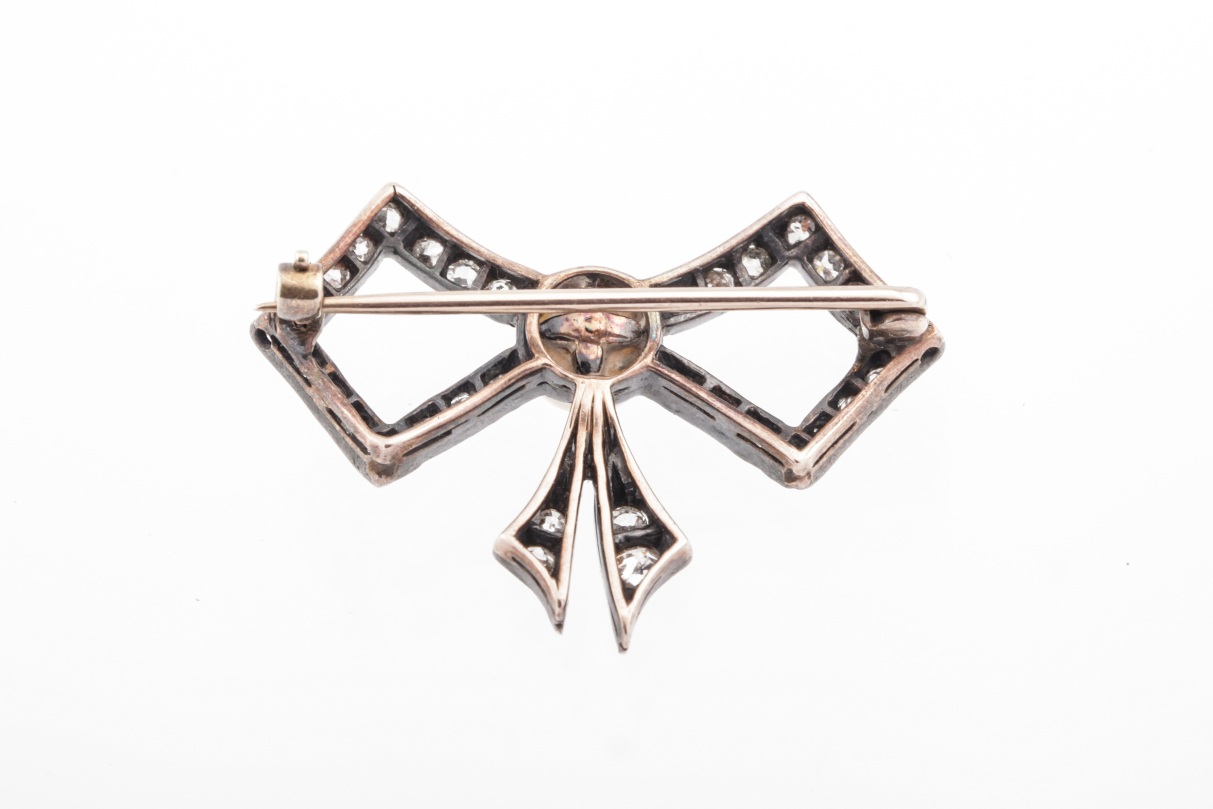 An early 20th century cultured-pearl and diamond bow brooch. Centred with a 5. - Image 2 of 2