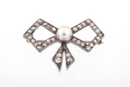 An early 20th century cultured-pearl and diamond bow brooch. Centred with a 5.