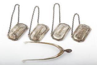 A matched set of four silver canted-rectangular decanter labels and sugar tongs.