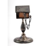 An early 20th century silver miniature lectern with a miniature leather bound copy of the New