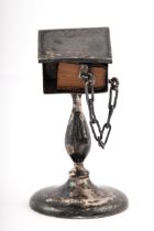 An early 20th century silver miniature lectern with a miniature leather bound copy of the New