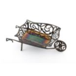 An Edwardian silver novelty sweet or bon bon dish modelled as a wheelbarrow.