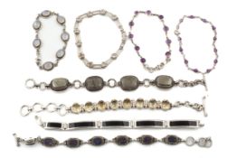 Eight white metal and stone set bracelets.