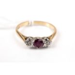 A mid-20th century gold, ruby and diamond three stone ring.