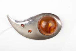 A vintage 1970s designer amber brooch in the form of a part polished and satinised stylised swoosh.