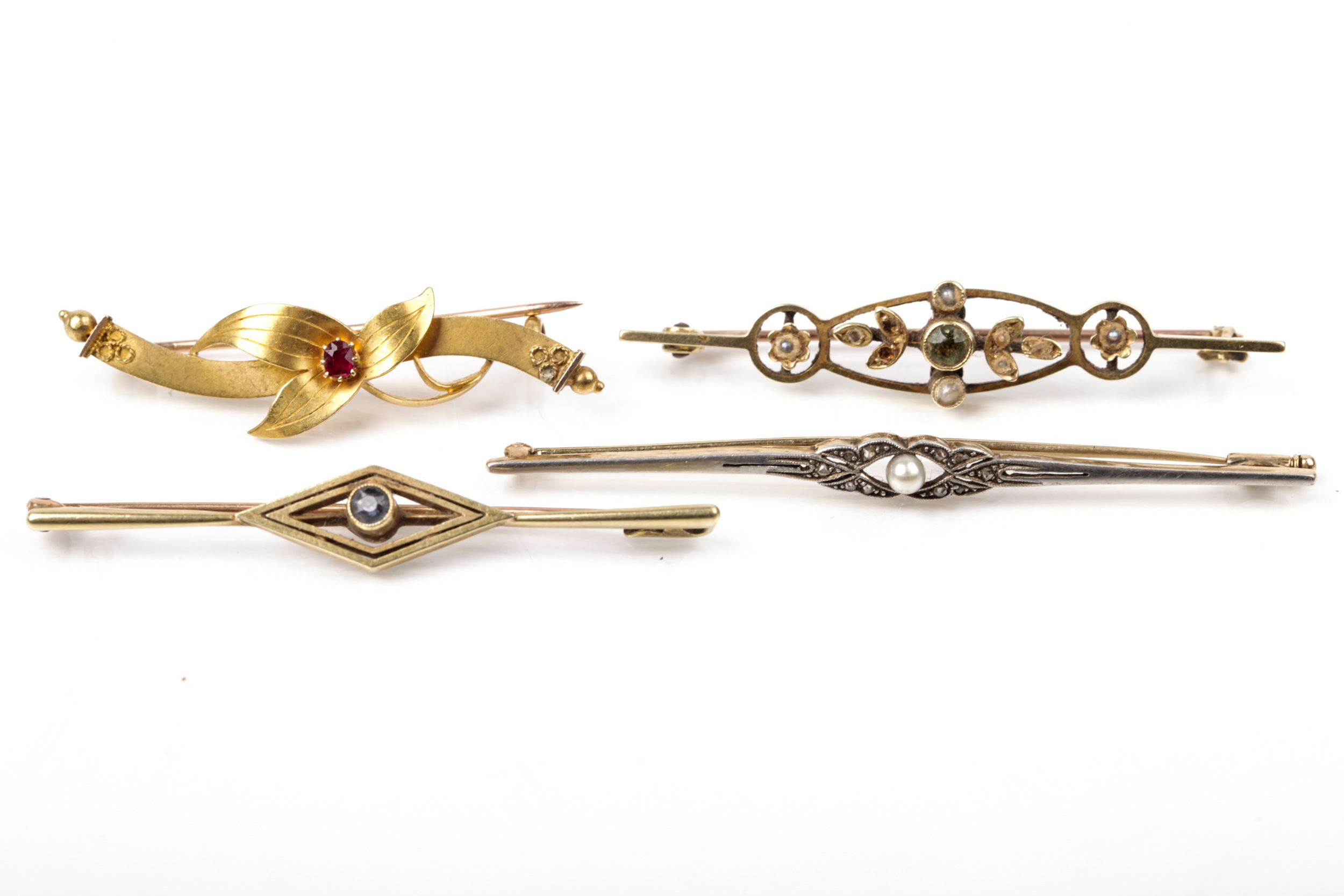 Four early 20th century gold and gem set brooches.