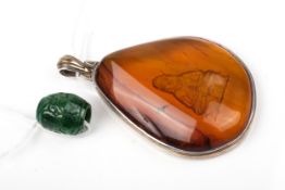 An Eastern jadeite single barrel-shaped bead, and an amber pendant.