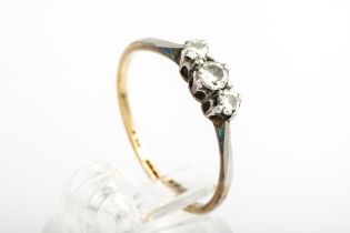 A mid-20th century gold and diamond three stone ring. The graduated round brilliants approx. 0.